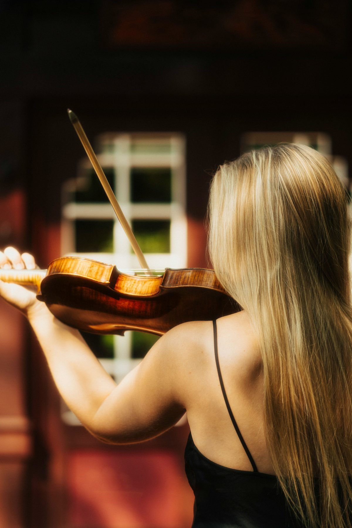 Violinist in a black dress performing at an intimate gathering